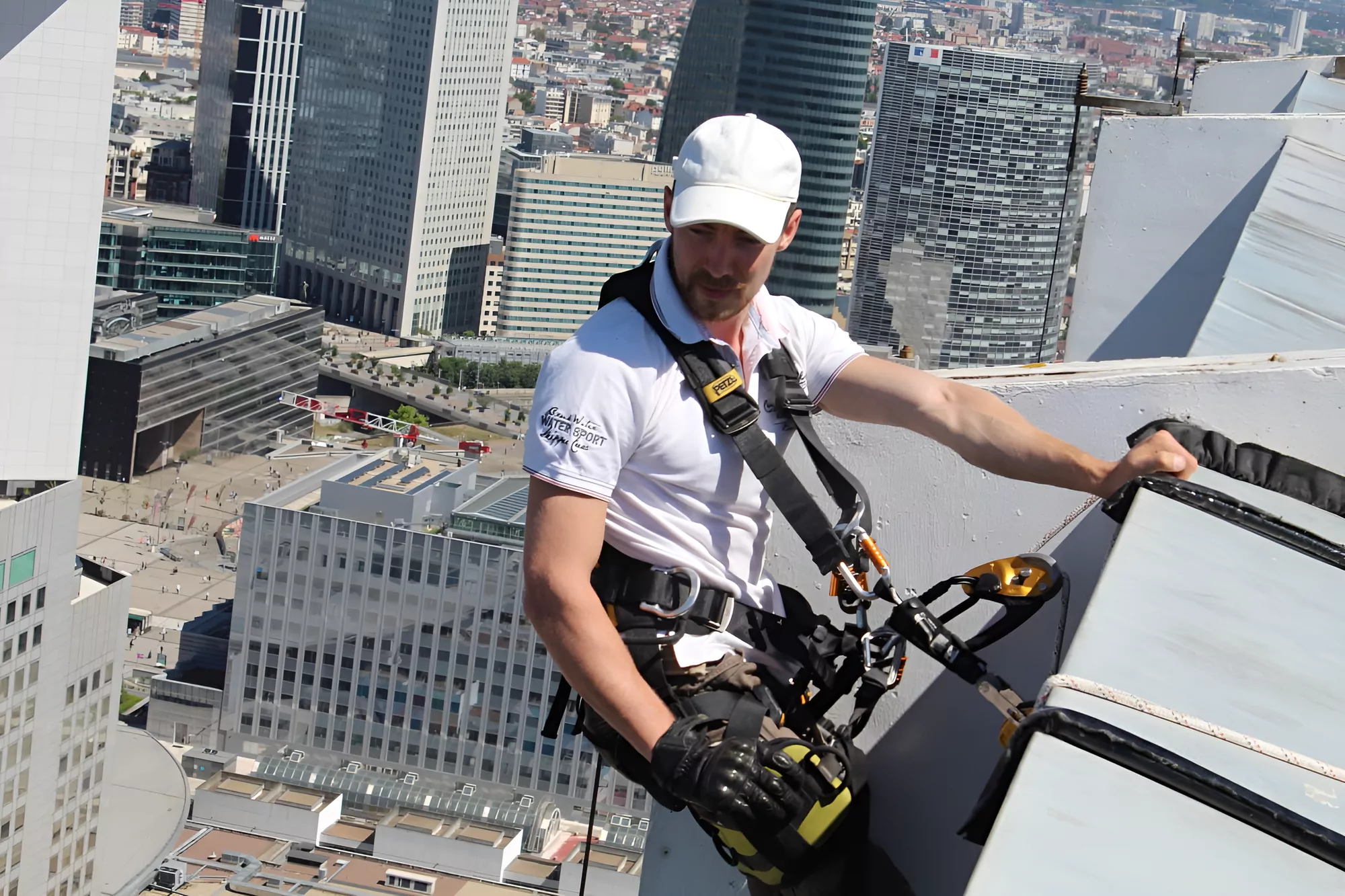 Cordiste au départ d'une descente, en rive de toiture à La Défense