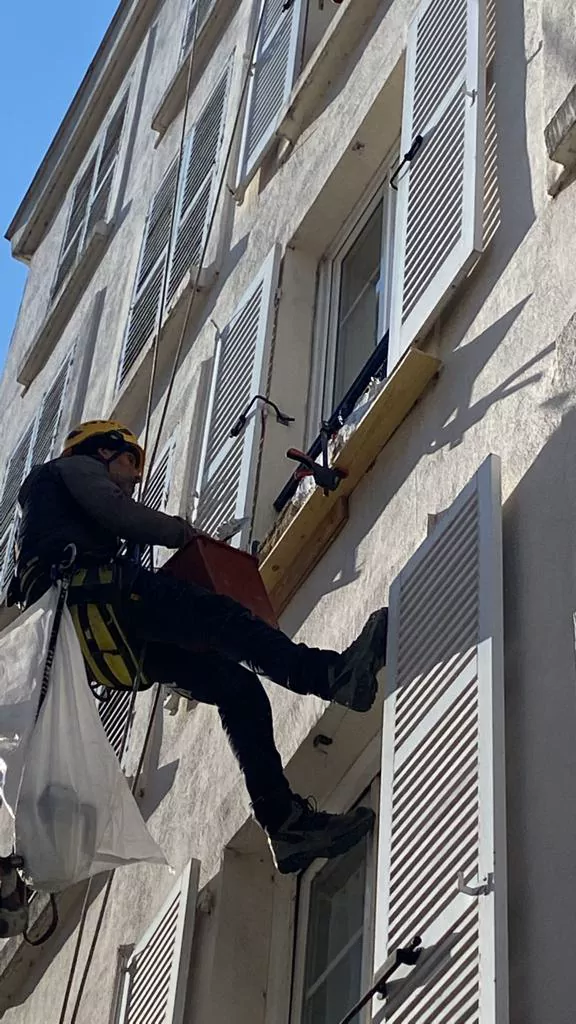Cordiste intervenant sur une façade à volets