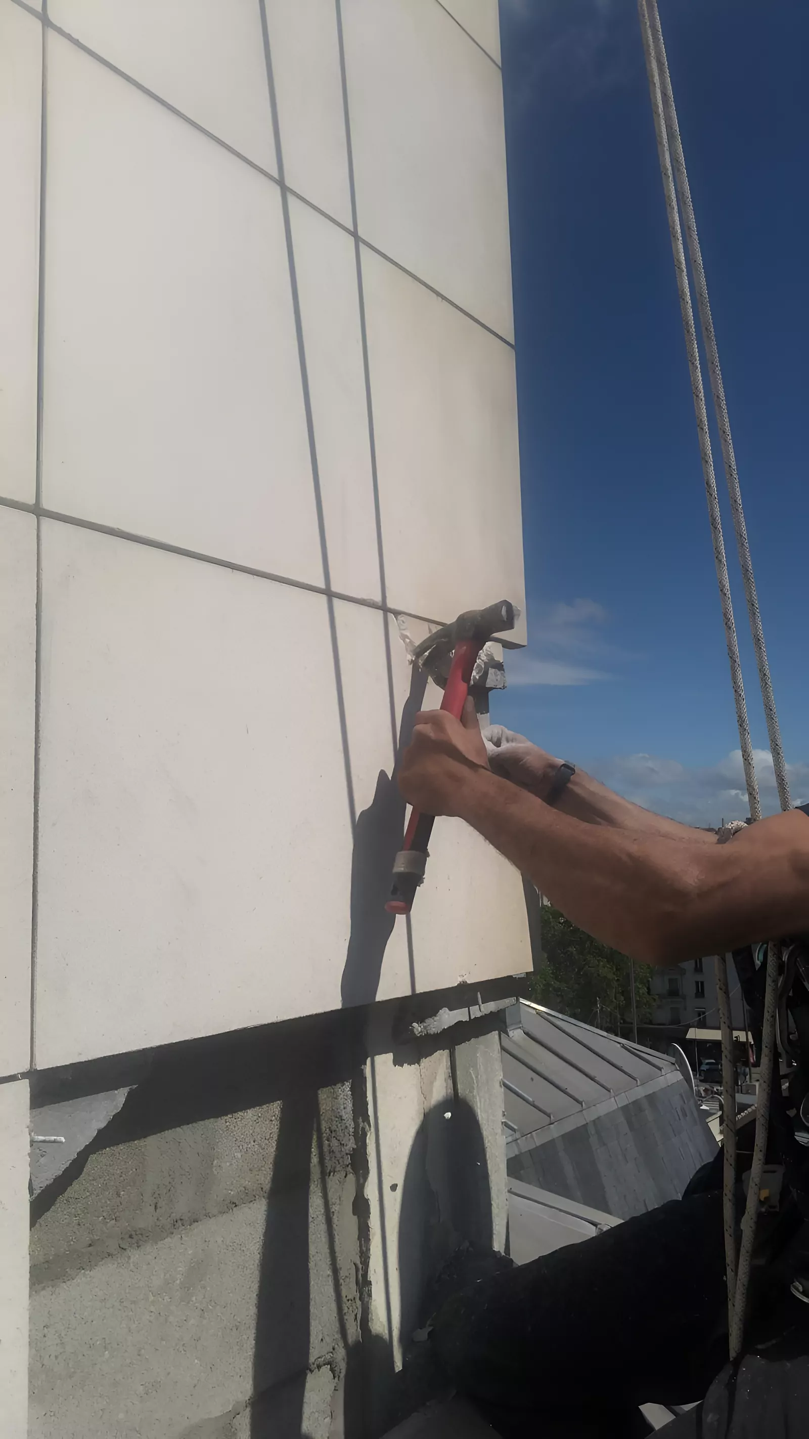 Cordiste au travail sur un bardage de façade