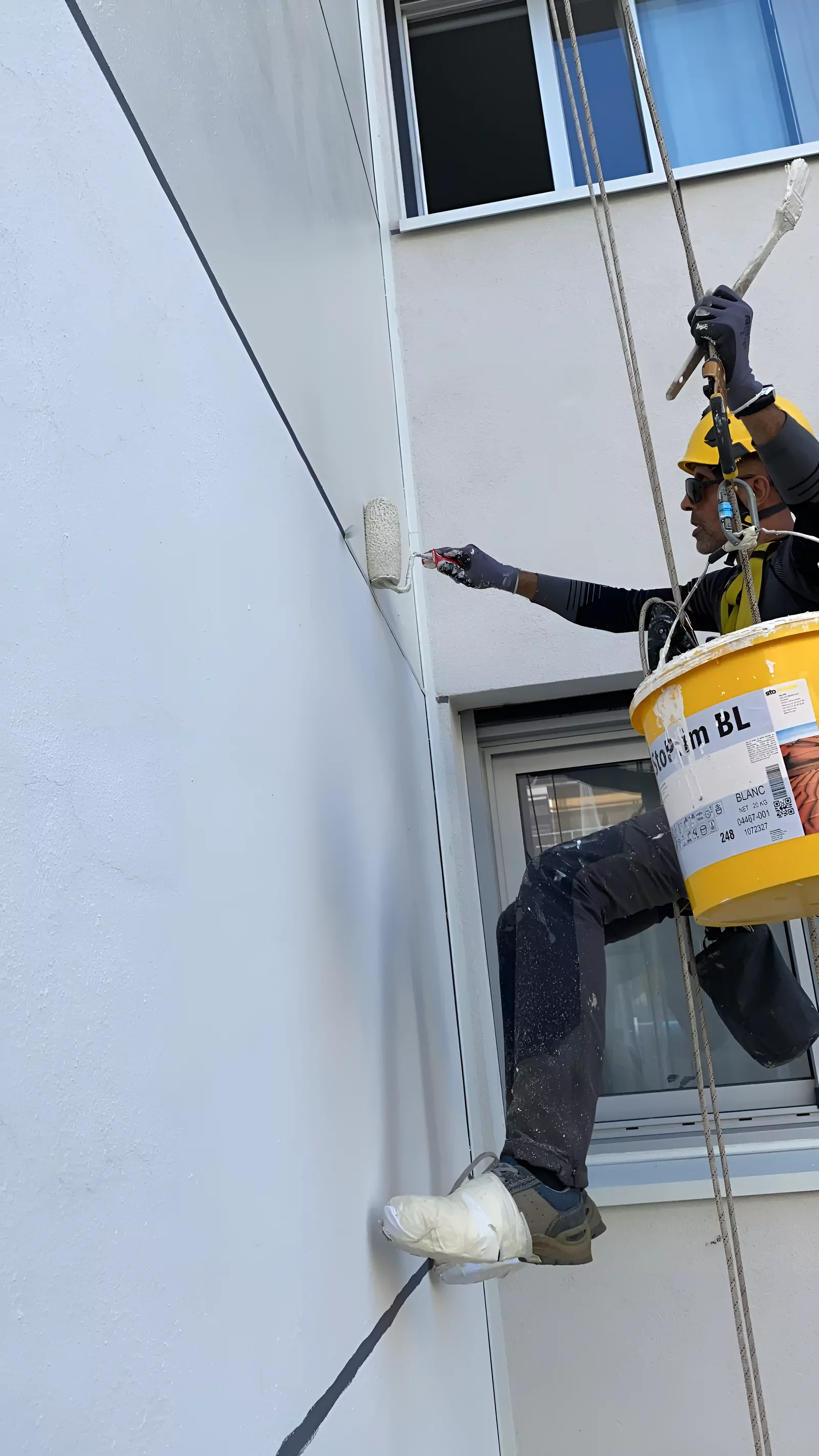 Cordiste en travaux de peinture sur une façade