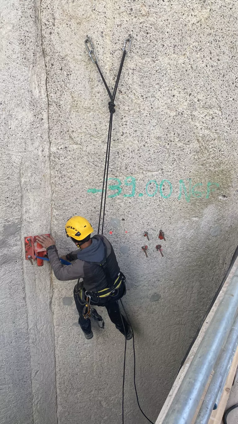 Cordiste au contact d'une façade en béton, relevés tracés sur le mur