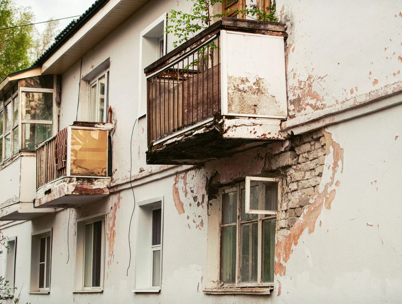 Balcon dégradé dont le nez et la sous-face s'effritent, brique apparente sous la dalle
