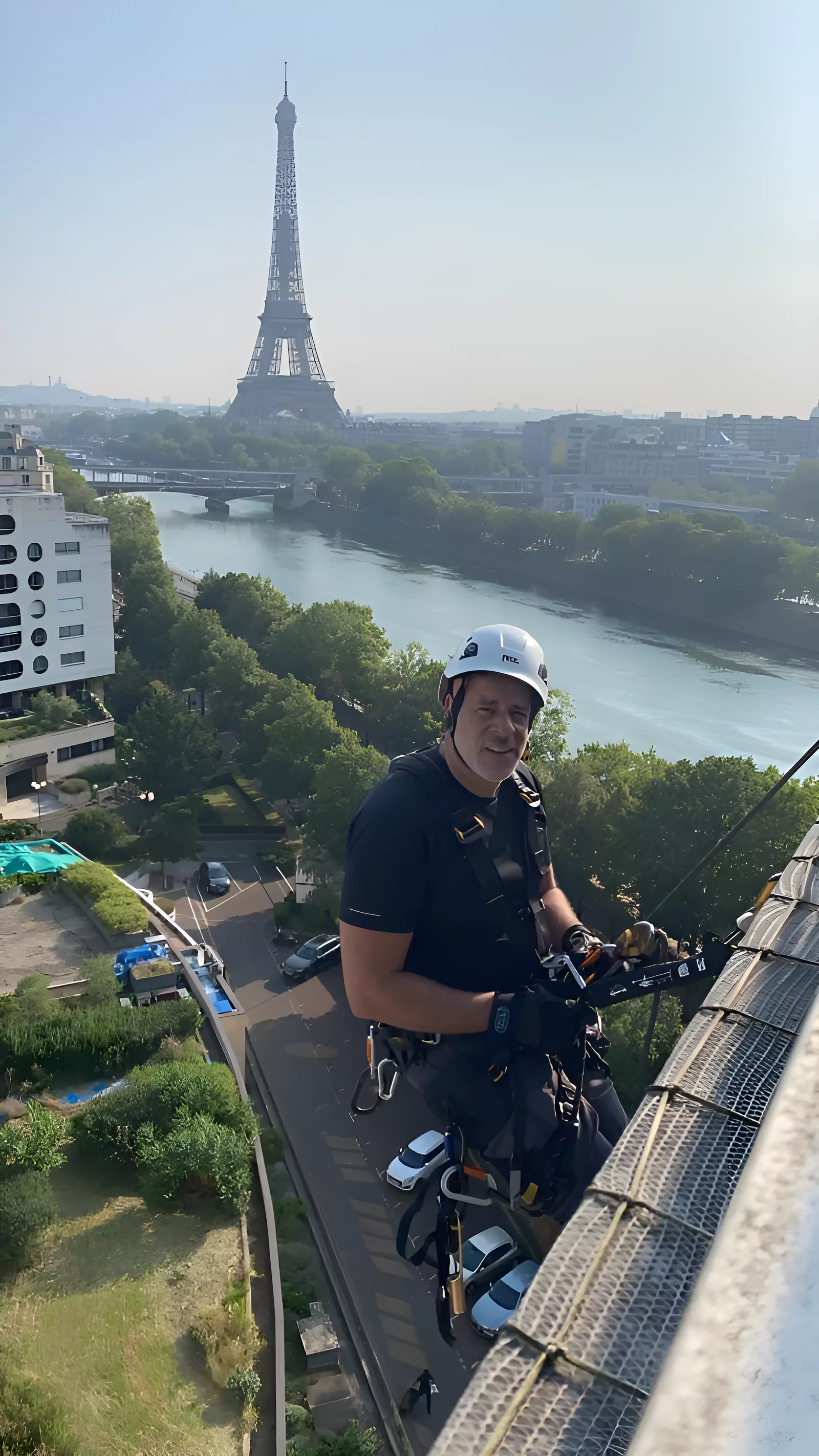 Cordiste équipé avant la descente, face à la Seine et à la tour Eiffel
