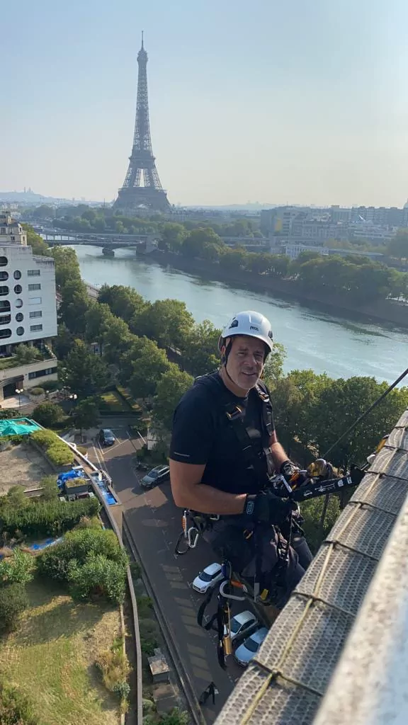 Cordiste équipé avant la descente, face à la Seine et à la tour Eiffel