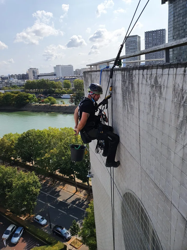 Cordiste sur une façade béton de grande hauteur