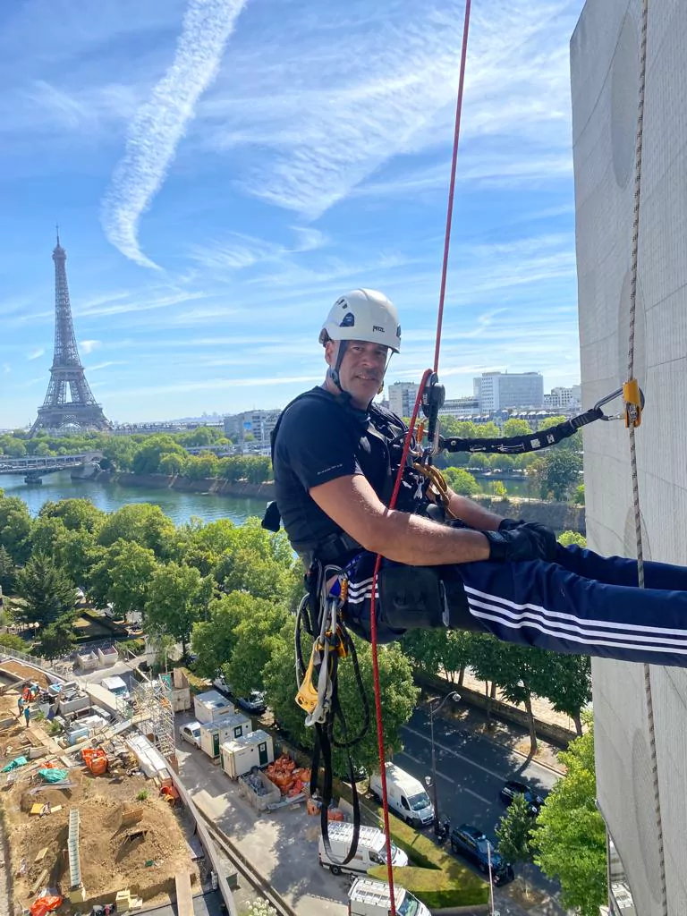 Cordiste certifié CQP en travaux sur façade face à la Tour Eiffel