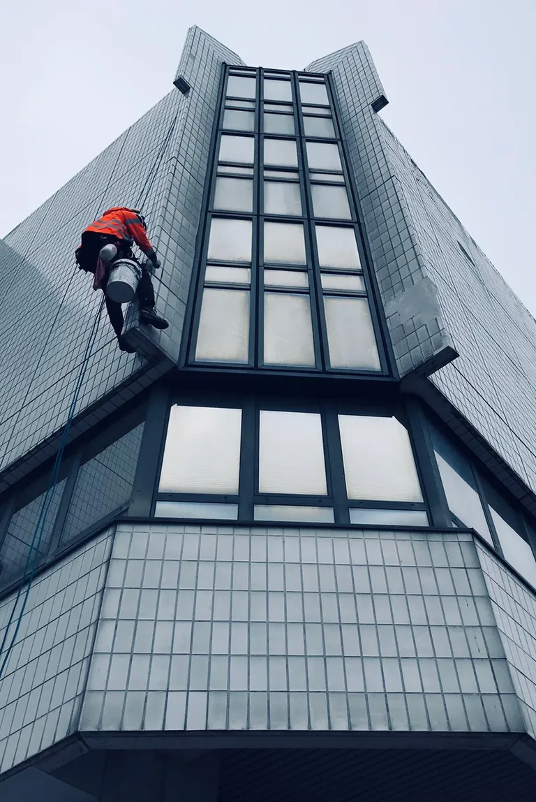 Cordiste en descente sur une tour vitrée