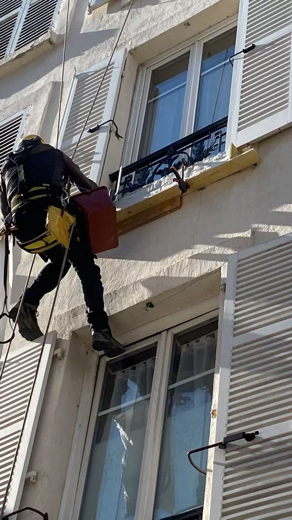 Cordiste intervenant sur une façade haussmannienne à Paris
