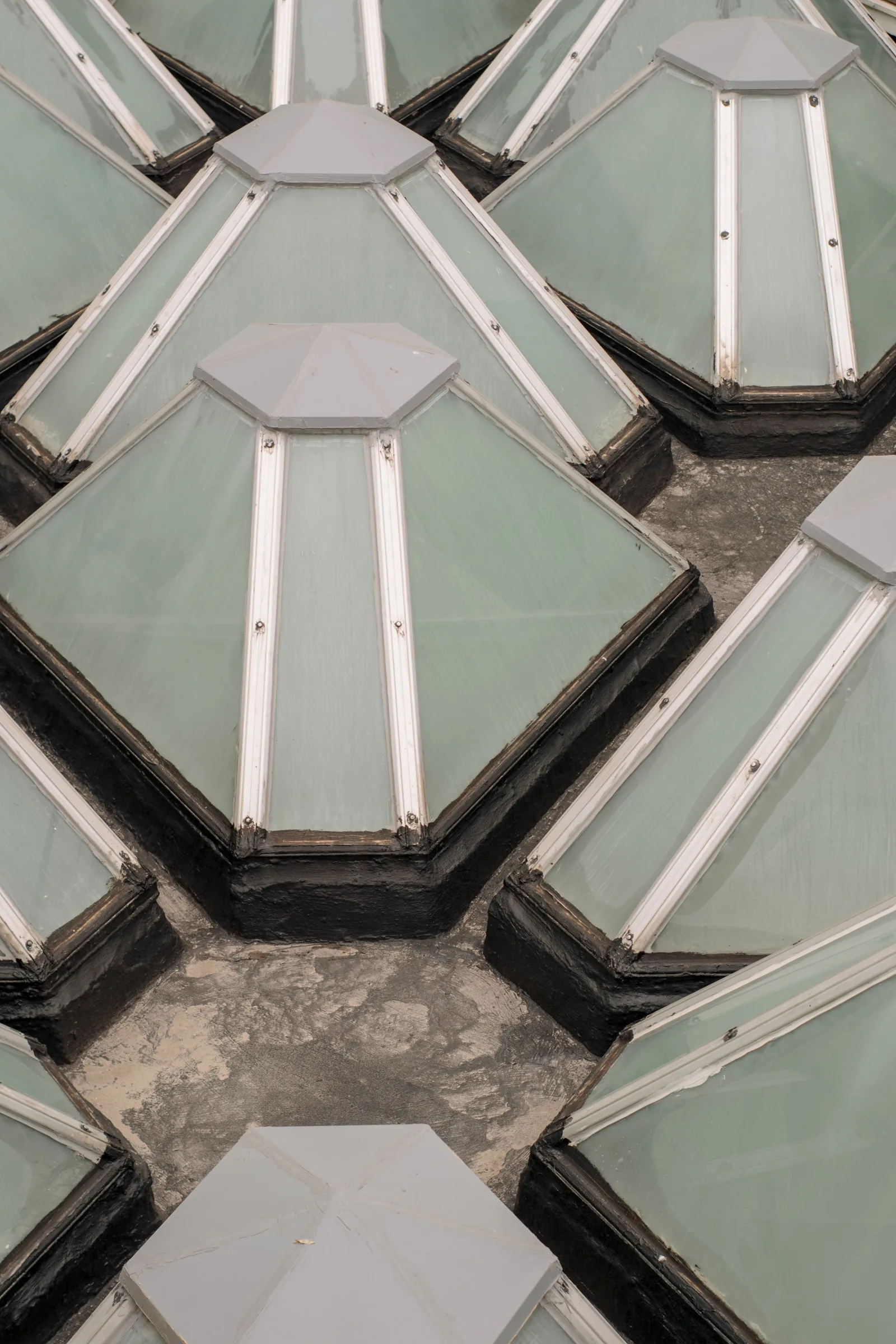 Lanterneaux pyramidaux en polycarbonate sur costières relevées, alignés sur une toiture-terrasse bitumée