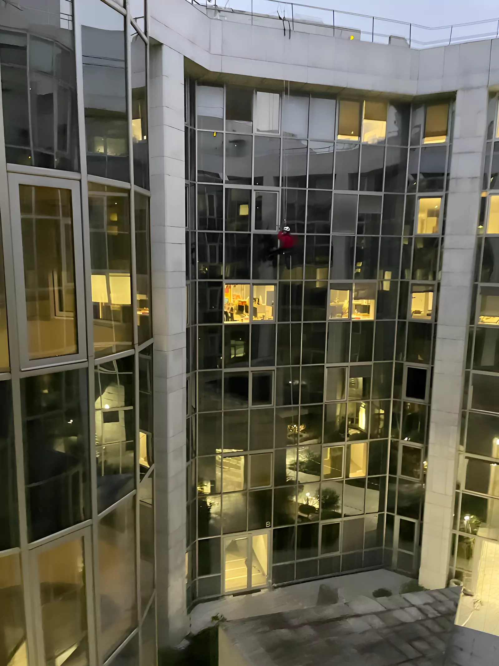 Cordiste sur la façade vitrée d'un immeuble de bureaux