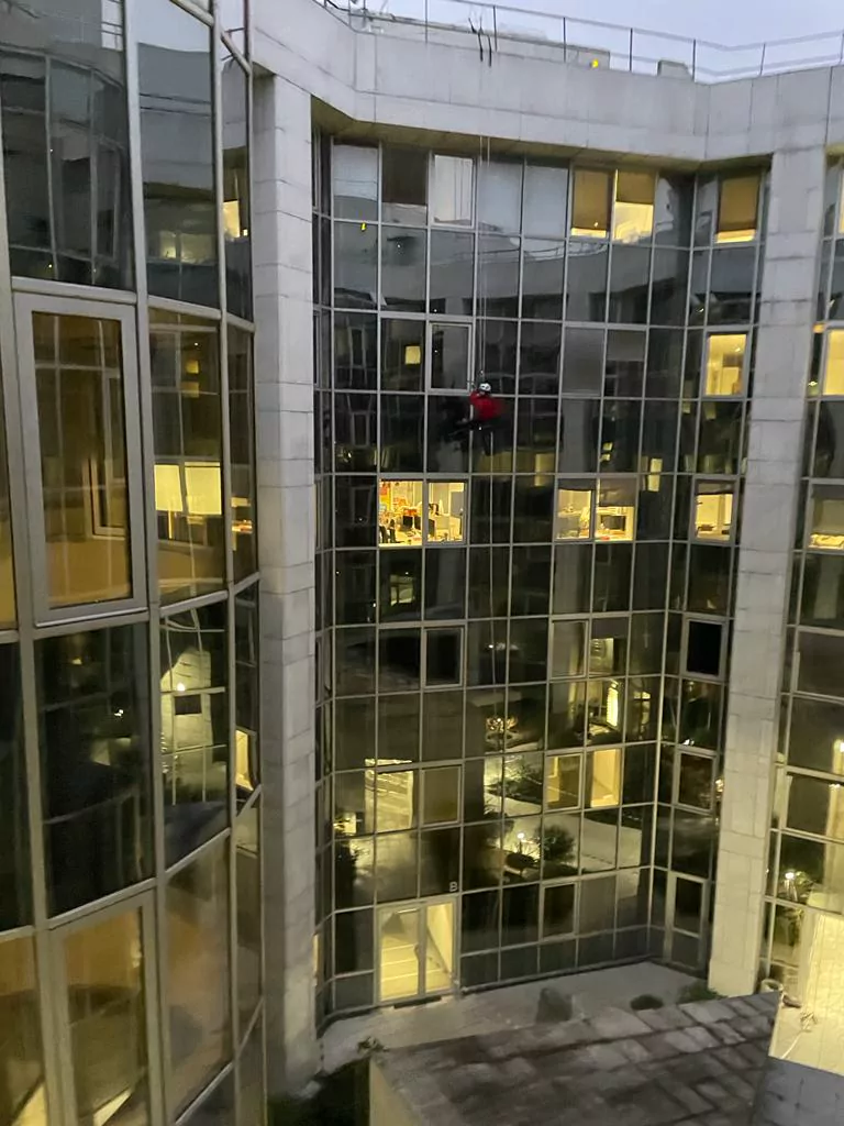 Cordiste sur la façade vitrée d'un immeuble de bureaux