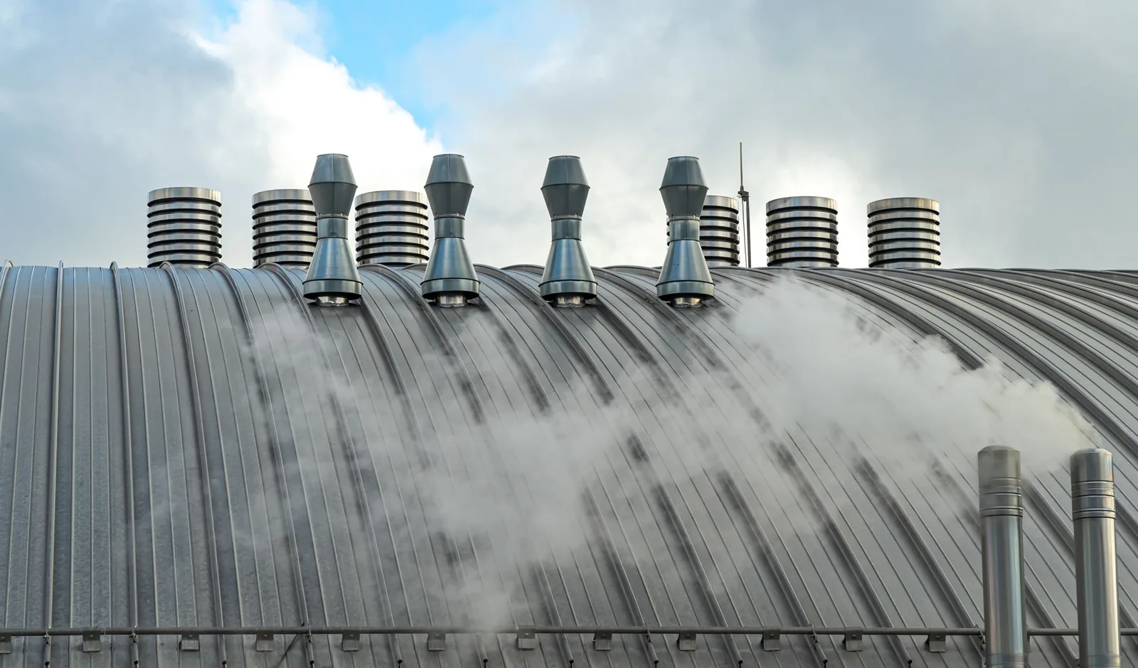 Toiture en bac acier d'un bâtiment industriel avec sorties de ventilation, cheminement d'entretien le long du faîtage