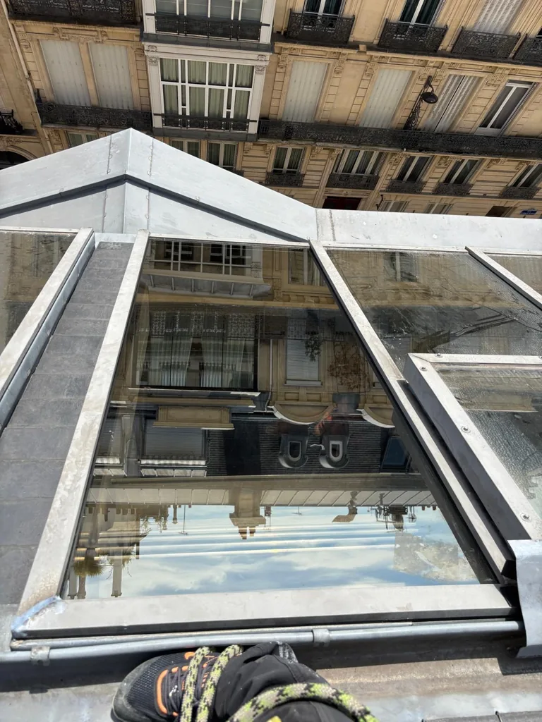Verrière pyramidale en toiture, cordiste au pied de la structure